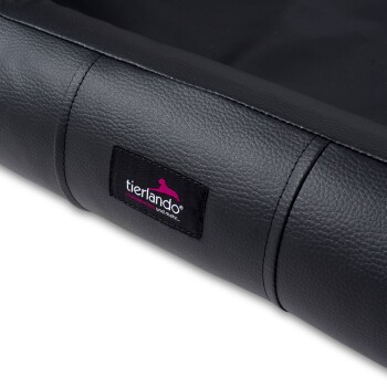 Ecke eines schwarzen Haustierbettes mit einem sichtbaren tierlando-Logoetikett, mit einer strukturierten lederähnlichen Oberfläche.