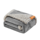 Ein gefaltetes graues Haustierdecke mit einer weichen, flauschigen beige Unterseite, mit einem kleinen orangefarbenen Etikett mit der Aufschrift "PetCuddles."