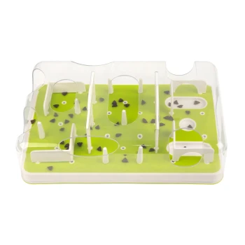 Interaktives grünes und weißes Hundeleckerli-Puzzle-Spielzeug mit transparenten Kunststoffbarrieren und verstreuten Leckerlis innen.