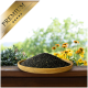 Eine Holzschale mit schwarzen Samen auf einer Holzoberfläche, umgeben von grünen Pflanzen und gelben Blumen, mit einem goldenen "PREMIUM" Banner.
