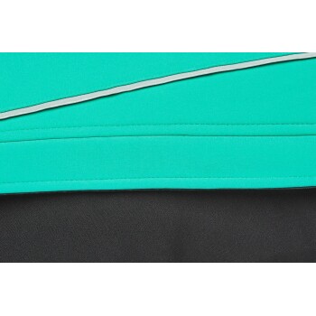 Nahaufnahme eines Haustierbekleidungsstücks mit einer lebhaften türkisfarbenen oberen Schicht mit grauem Rand, die über einem schwarzen unteren Stoff liegt.