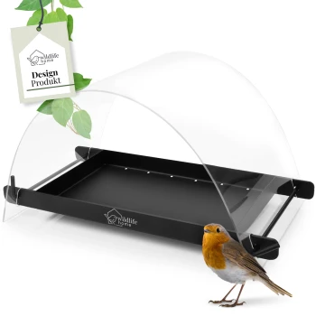Ein schwarzer Vogelfutterspender mit einer klaren Kuppelabdeckung, begleitet von einem kleinen Rotkehlchen und einem Etikett mit der Aufschrift 'wildlife home Design Produkt'.