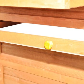 Holz-Haustieraufbewahrungseinheit mit einem gelben Knopf, die ein sauberes, leeres Regal zeigt.