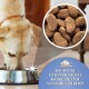 Ein Hund frisst aus einer Edelstahlschüssel, die mit knusprigen Hühnerkroketten gefüllt ist. Text: "Knusprige Hühnerbasierte Kroketten mit Vollkorngetreide."