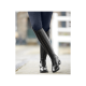 Eine Nahaufnahme einer Person, die stilvolle schwarze Reitstiefel mit dekorativer Schnürung und niedrigem Absatz trägt, kombiniert mit marineblauen Reithosen.