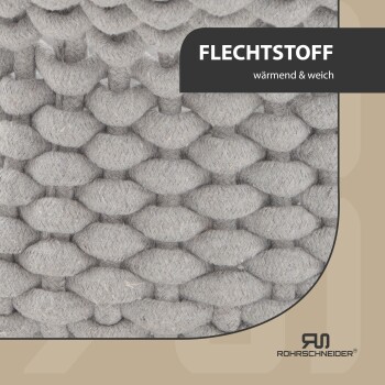 Nahaufnahme eines weichen, grauen gewebten Stoffes mit dem Text "FLECHTSTOFF" und "wärmend & weich", was auf Wärme und Weichheit hinweist.