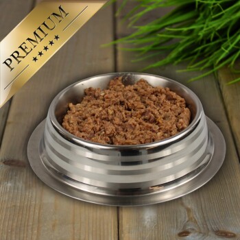 Eine Edelstahlschüssel für Haustiere, gefüllt mit hochwertigem Nassfutter für Katzen, beschriftet mit "PREMIUM", auf einer Holzoberfläche mit grünem Gras im Hintergrund.