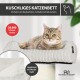 Beiges Cordstoff-Katzenbett mit herausnehmbarem Kissen neben einer Waschmaschine; sichtbarer Text ‚MASCHINENWASCHBAR‘ und ‚30 °C waschbar‘.