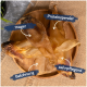 Getrocknete Fischleckerlis auf einem Holzbrett beschriftet: "mager," "Proteinsspender," "Belohnung," und "zahnpflegend."