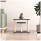 Eine verspielte getigerte Katze sitzt auf einem zweistufigen Katzenbaum mit einem grauen oberen Teil und beigen Pfosten, der in einem gemütlichen Wohnzimmer platziert ist.