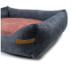 Ein plüschiges Haustierbett mit einem dunkelblauen Äußeren und einem weichen rosa Inneren, mit einem Lederetikett, das "RexProduct.com" liest.