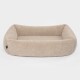 Ein gemütliches, beiges Haustierbett mit plüschigem, flauschigem Stoff und erhöhten Rändern, entworfen für kleine bis mittelgroße Haustiere.