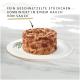 Hundefutter auf einem weißen Teller, mit fein zerrissenen Stücken in einer hellen Sauce, mit deutschem Text, der das Produkt beschreibt.