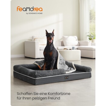 Dobermann auf grauem Feandrea-Hundebett mit Decke in einem Wohnzimmer; sichtbarer Text 'feandrea by SONGMICS HOME' und deutscher Slogan.