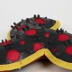 Red and black dog booties with yellow trim and rubber spikes for traction, shown close-up on a white background.
