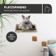 Graue Katze mit orangen Augen ruht auf einem wandmontierten Holz-Katzenbett, sichtbare Texte „PLATZSPAREND“ und „keine Stellfläche nötig“.