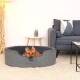 Ein gemütliches graues Haustierbett mit einem weichen Innenraum, in dem ein kleiner Hund ruht, in einem modernen Wohnzimmer mit einem grauen Sofa und einem dekorativen Tisch.