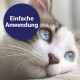 Eine silberne getigerte Katze mit auffälligen grünen Augen liegt auf einer hellgrauen Oberfläche, mit dem Text 'Entfernt Tränenflecken' in Pink darunter.