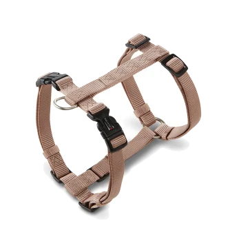 Beiges, verstellbares Hundegeschirr aus Nylon mit schwarzen Kunststoffschnallen, Metall-D-Ringen und kleinem weißem Logo an der mittleren Schnalle.