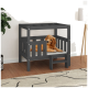 Ein Golden Retriever Welpe, der auf einem stilvollen grauen Holzhaustierbett mit einer kleinen Stufe entspannt, in einem modernen Raum mit einer Pflanze und einer Lampe.