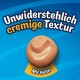 Blaues Tierfutteretikett mit cremig-braunem Futterklecks und dem Text 'Unwiderstehlich cremige Textur, Mit Huhn'.
