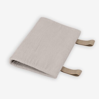 Eine weiche, beige Haustierdecke mit gerippter Textur, mit zwei Stoffriemen an den Seiten für einfaches Handling.