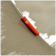Nahaufnahme einer beige Ecke eines Haustierbettes mit einem orangefarbenen Etikett, das "95°" an dem Stoff befestigt ist.