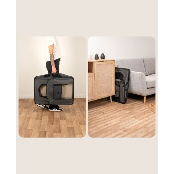 Eine Person hält eine schwarze Tragetasche für Haustiere mit einem hellbraunen Innenraum auf Holzboden, die ein Haustierbett im Inneren zeigt. Ein modernes Wohnzimmer ist im Hintergrund.