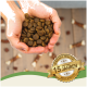 Ein Paar Hände hält einen Haufen brauner Tierfutterkibble, mit einem Abzeichen, das "Bewährte Qualität seit über 15 Jahren" und "Beste Qualität" liest.