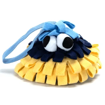 Ein farbenfrohes, plüschiges Haustierspielzeug in Form eines Meereslebewesens, mit gelbem und blauem Stoff, großen weißen Augen und einem blauen Riemen.