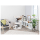Eine flauschige Katze klettert auf einen mehrstöckigen Katzenbaum in einem modernen Wohnzimmer mit grauer Wand, einem gemütlichen Stuhl und dekorativen Pflanzen.