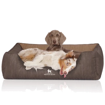 Ein gemütliches braunes Hundebett mit einem Logo, das "KNUFFELWUFF" liest, mit einem entspannten Hund, der bequem darauf liegt.