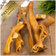 Hochwertige Hundekauartikel auf einer Holzoberfläche präsentiert, mit mehreren verdrehten, bräunlichen Streifen.