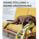 Ein brauner Hund auf einer gelben Couch kaut auf einer Plüschschlange. Text: "Kein Füllmaterial = kein Durcheinander. Diese Spielzeuge haben keine Füllung für mehr Spaß."