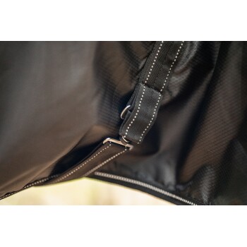 Nahaufnahme eines schwarzen Haustiergeschirrs mit einem Metallclip und robuster Naht, das sein haltbares Design zeigt.