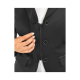 Eine Nahaufnahme einer Hand einer Frau, die den Reißverschluss einer schwarzen Jacke anpasst, mit zwei silbernen Knöpfen und einem weißen Hemd darunter.