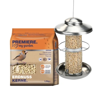 Eine Tüte Erdnuss-Vogelfutter mit der Aufschrift "Premiere. Ich ❤️ meinen Garten" neben einem Metall-Vogelfutterspender, der mit Erdnüssen gefüllt ist.