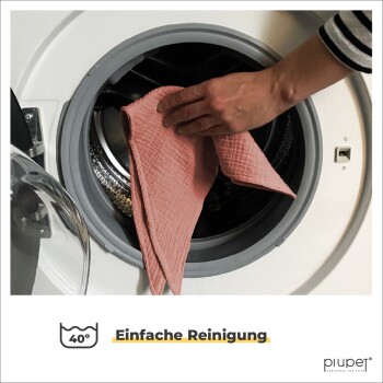 Eine Hand, die ein pinkes Tuch in eine Waschmaschine legt, mit dem Text "40° Einfache Reinigung" und dem Logo "piupet® Designed for Pets" darunter.