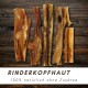 Fünf getrocknete Rinderkopfhaut-Kauknochen für Hunde auf Holzuntergrund mit Text „Rinderkopfhaut 100 % natürlich ohne Zusätze“.