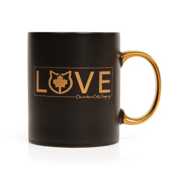 Schwarze Keramiktasse mit goldenem Griff, mit 'LOVE' in fettem Gold und einer Katzensilhouette mit einem Ahornblatt.