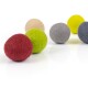 Eine Sammlung von bunten Filzkugeln in Rot, Grün, Beige, Grau und Gelb, in einer Reihe auf einer weißen Oberfläche angeordnet.