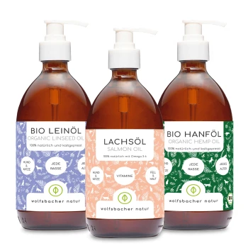 Drei Flaschen Haustieröle: Bio-Leinöl, Lachsöl und Bio-Hanföl, jeweils mit bunten Etiketten und Pumpenköpfen.