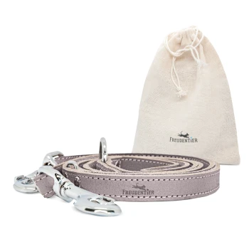 Hundeleine aus zertifiziertem Leder 2m, verstellbar braun/ grau 2 cm Eine stilvolle graue Hundeleine mit silbernen Clips, neben einem beigen Zugbeutel mit dem Logo "FREUDENTIER."