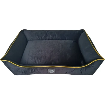 Black pet bed with yellow trim, featuring a plush interior and a label that reads "Beddies® MADE IN IRELAND."