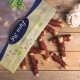Eine Tüte mit Haustierleckerlis, die teilweise geöffnet ist und mehrere gerollte Leckerlis, die mit Fleisch überzogen sind, auf einer Holzoberfläche verstreut zeigt.