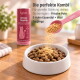 Katzenkroketten in weißer Schüssel, rosa Schaufel streut 'Urinary Topping'-Pulver darüber, daneben rosa KatKare-Dose.