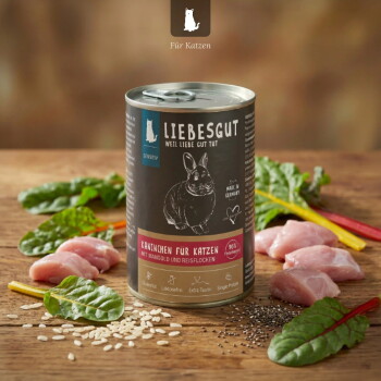 Liebesgut-Dose 'Kaninchen für Katzen' (Kaninchen) umgeben von rohem Fleisch, Mangold, Reis und Samen auf einer Holzoberfläche.