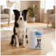 Schwarz-weißer Border Collie sitzt drinnen neben einem verpackten Haustierprodukt mit der Aufschrift 'WECHSEL-EINLAGEN' und 'HYGIENE'.