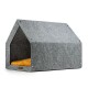 Graues Filzhaustierhaus mit einem gemütlichen gelben Kissen innen, in Form eines Hauses gestaltet.