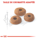 Trois croquettes rondes pour animaux de compagnie avec un trou au centre, affichées sur un léger croquis de mesure, avec le texte "TAILLE DE CROQUETTE ADAPTÉE" au-dessus.